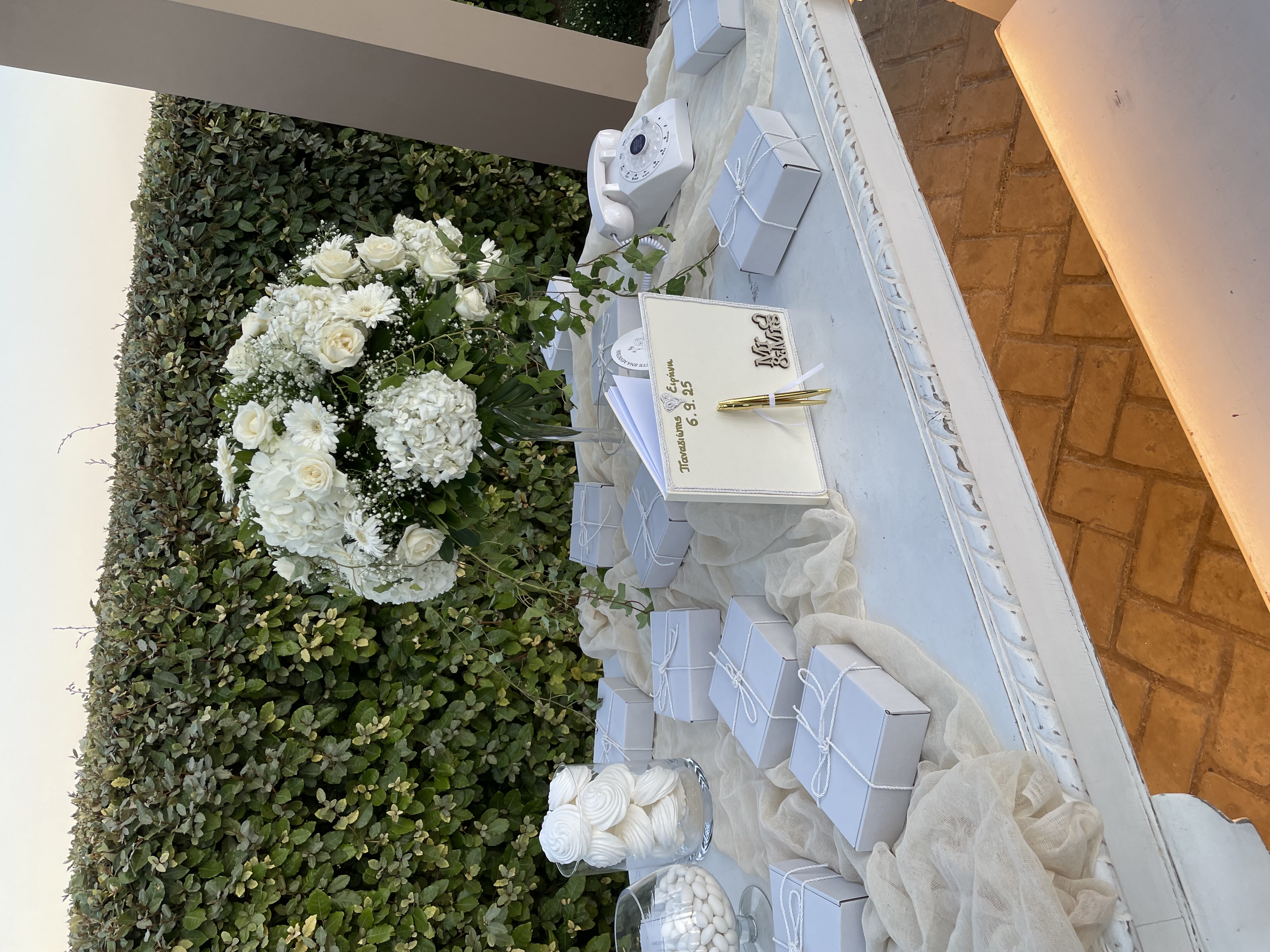 Στολισμός τραπεζιού με λευκά λουλούδια και μπομπονιέρες