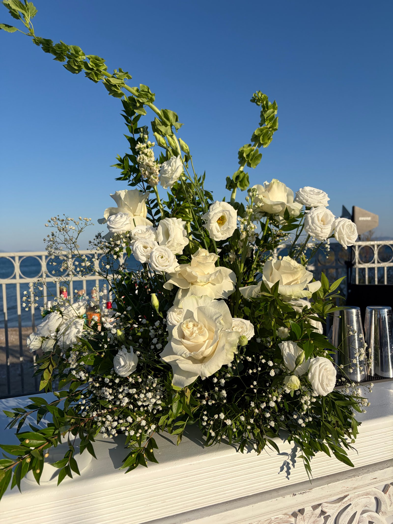 White bouquet at a bar with a sea view