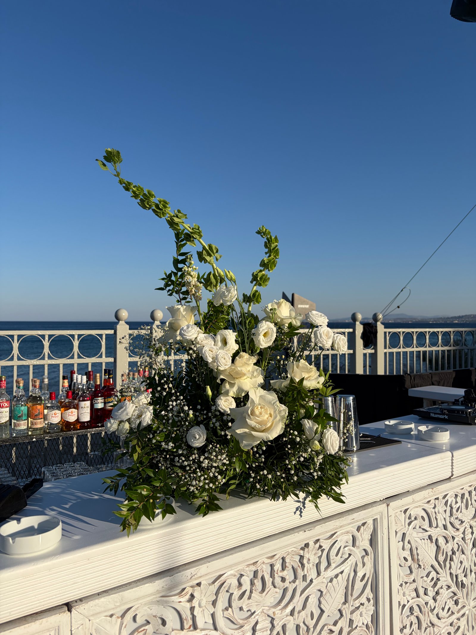 White bouquet at a bar with a sea view