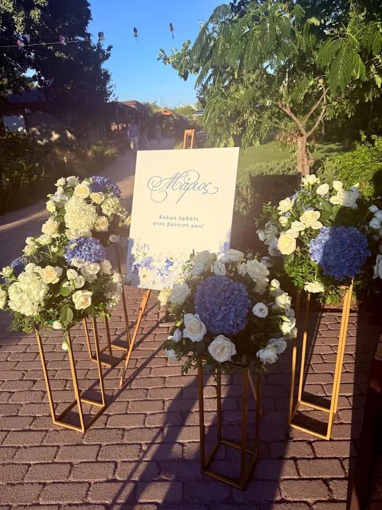 Christening church-entrance styling with white roses and blue hydrangeas