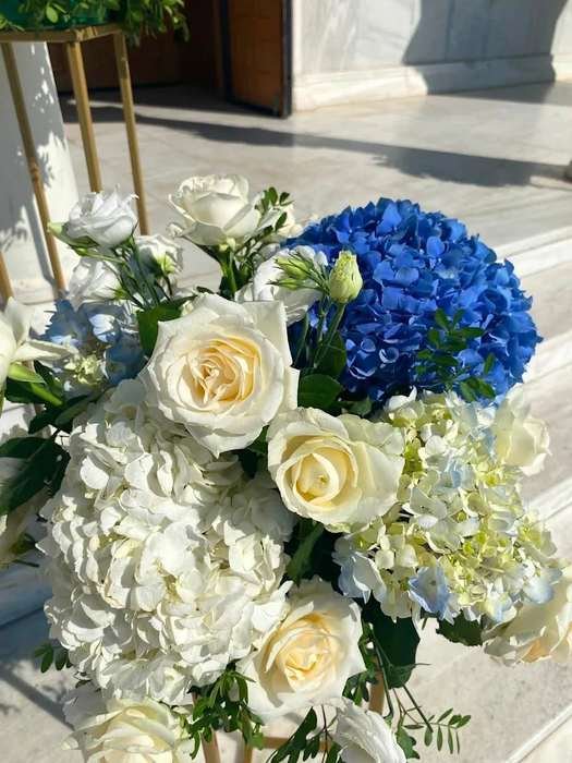 Detail of christening styling with white roses and blue hydrangeas